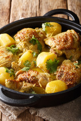 Asian chicken coconut curry with potatoes close-up in a pan. vertical
