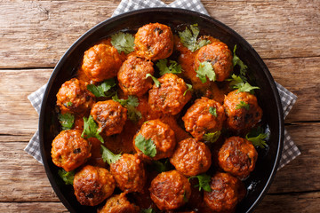 spicy chicken Indonesian Meatballs come complete in a creamy coconut curry sauce close-up on a plate. horizontal top view