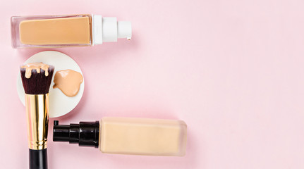 Liquid fluid foundation glass bottle on makeup sponges and brush makeup.