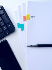 Office desk table with computer keyboard and supplies. On white background. Top view with copy space. Mock up