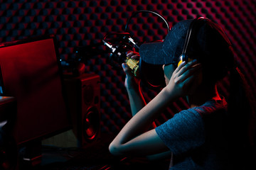 Young Adult play game e-sport online with gang. Woman connect social media with professional equipment such as e-sport gaming keyboard, mouse, monitor, speaker, camera, studio, dark red blue theme