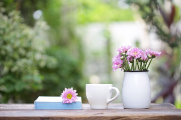 white coffee cup with flower pot and notebook on wooden table