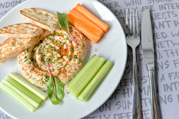 hummus with croutons and vegetables on a plate