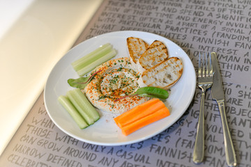 hummus with croutons and vegetables on a plate