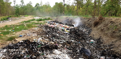environmental damage of garbage in the nature. garbage and smog in forest.