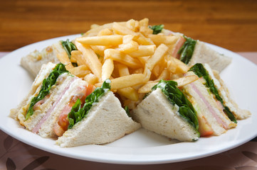 Sandwich club, ham, cheese, vegetables and mayonnaise. Accompanied by french fries