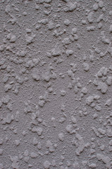 Background, texture of a modern plastered facade of a residential building. Exterior wall cladding machine gray plaster.