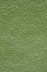 Background, texture of a modern plastered facade of a residential building. External facing of walls by machine plaster of green color.