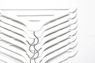 Flat lay top view White wooden hangers on white background copy space minimalism style. Sale discount store shopping concept, design empty hanger. Creative fashion beauty feminine blog