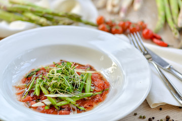 asparagus with tomato sauce on a white plate