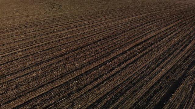 Drone shot of brown field. Agricultural field. Brown soil farm landscape. Line of arable land. Pattern field. Land prepared for planting vegetables.