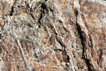 Macro view of cracked stone surface brown and gray color. Detailed nature background or pattern texture taken in natural environment. Weathered over years, unique, inimitable effect to textured design