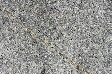 Close up macro view of rough gray stone surface. Detailed nature background or pattern texture taken in natural environment. Weathered over years, unique and inimitable effect to textured design.