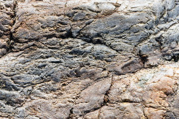 Macro view of cracked stone surface brown and gray color. Detailed nature background or pattern texture taken in natural environment. Weathered over years, unique, inimitable effect to textured design