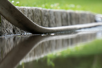 Reflektion eines Schlauches in Wasserlacke