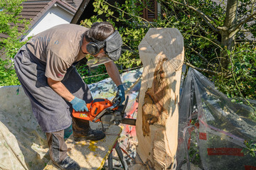 Holzbildhauer verfertigt eine Holzskulptur mit Motors&auml;ge, Stans, Nidwalden, Schweiz