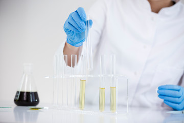 Scientist tearing the CBD oil from one tube into another