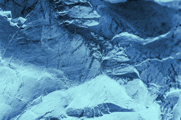 Vintage blue background. Rough painted wall of sapphire color. Imperfect plane of blue colored. Uneven old decorative toned backdrop of cyan tint. Texture of sapphirine hue. Ornamental stony surface.