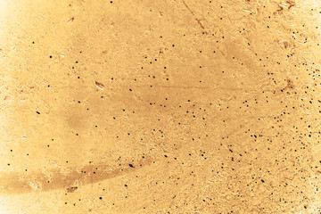 Vintage yellow background. Rough painted wall of aspen gold color. Imperfect plane of golden colored. Uneven old decorative toned backdrop of yellow tint. Texture of gold hue. Ornamental stony surface