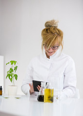 Scientist checking a pharmaceutical cbd oil in a laboratory with a tablet