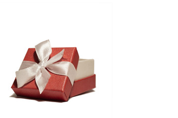 A beautiful red box with a white ribbon. Packaging for a gift on a holiday.