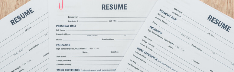 panoramic shot of print resume templates on wooden surface