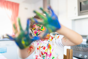 Cheerful child painting with colorful paint