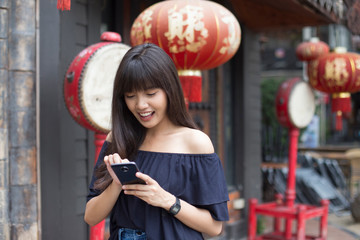Fototapeta na wymiar smiling young asian woman enjoy with smart phone