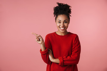 Image closeup of nice african american woman looking at camera and pointing finger on copyspace