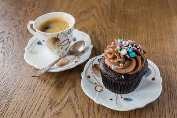 Black coffee and chocolate muffin with cream hat