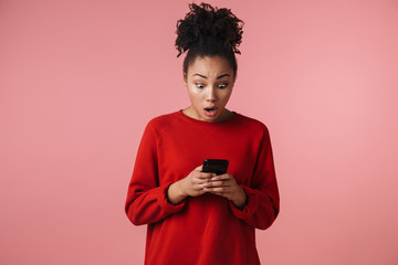 Image closeup of surprised african american woman typing on cellphone with open her mouth