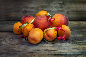 Ripe fruits of peaches and apricots close up on a wooden board