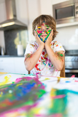 Cheerful child painting with colorful paint