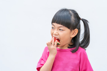 Asian little girl is eating a slice of watermelon