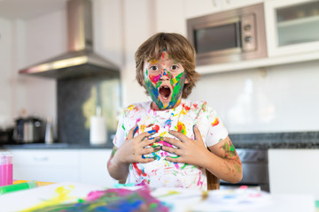 Cheerful child painting with colorful paint
