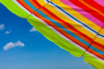 Colorful beach umbrella and blue sky with copy space.