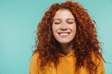 Photo closeup of optimistic woman 20s with curly ginger hair smiling at camera