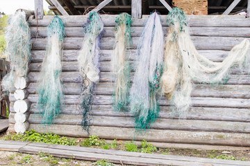 Fishing nets are dried on a log wall
