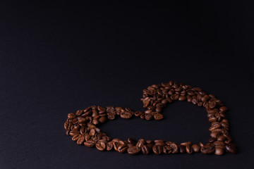 On a dark background contour heart from coffee in the right corner