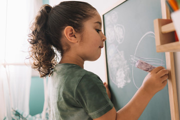 little girl drawing on the chalkboard