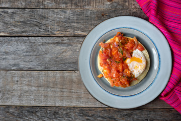 Mexican food: Fried egg rancheros with sauce and corn tortilla