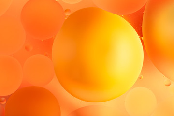 oily drops in water with colorful background, close-up 