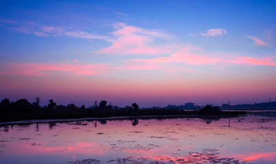 Naklejka premium Scenic beauty of a pre dawn colourful winter morning near a lake. Natural calm lake water reflecting the romantic and beautiful cloud and sky