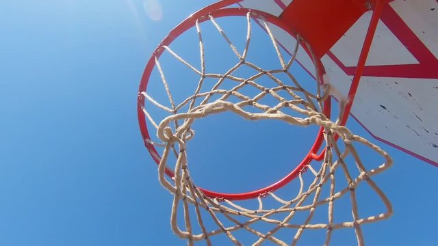 Close-Up Of Street Basketball Board And Bow With Net Illuminated By Sunlight. Slow Motion Moving Backward.