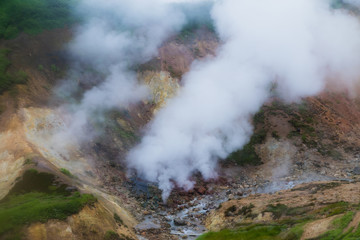 Fototapeta na wymiar A small valley of geysers near the Mutnovsky geo power station in Kamchatka