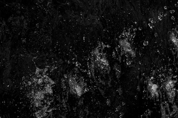 splashes and flying drops of water on a dark background, bokeh defocused 