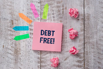 Handwriting text writing Debt Free. Conceptual photo does not owning any money or things to any individual or companies Plain note paper and line arrow stickers on the top of wooden table desk