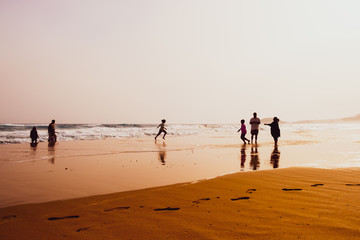 Fototapeta na wymiar Silhouettes of people playing in sandy Golden Beach, Karpasia, Cyprus