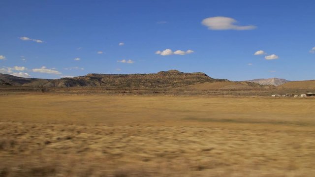 Desert country side with mountains in background on train