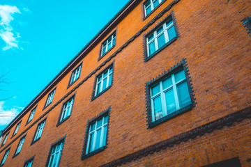 brown brick house with big blue windows